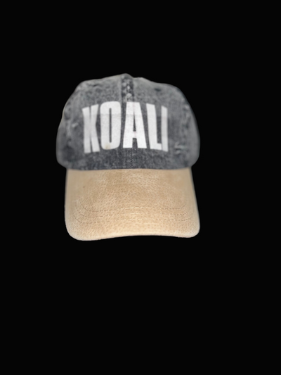 Gray and beige cap with 'KOALI' text on a dark surface